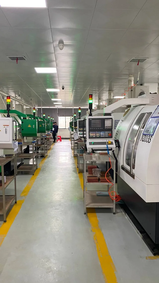 Workshop aisle between rows of enclosed machines and their control panels