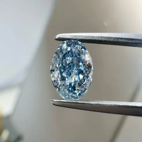 Blue oval diamond held in tweezers, from DiamovaLab supplied photographs