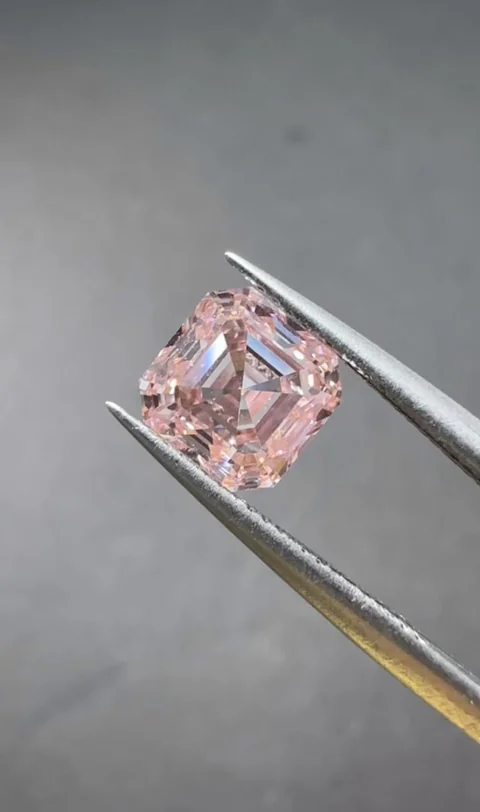 Pink square step cut diamond held in tweezers, supplied photograph