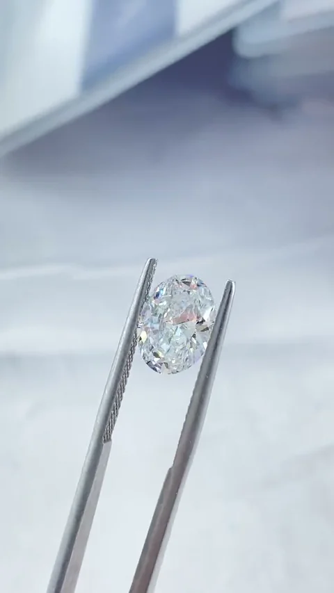 Oval white diamond held in tweezers, extracted from supplied video
