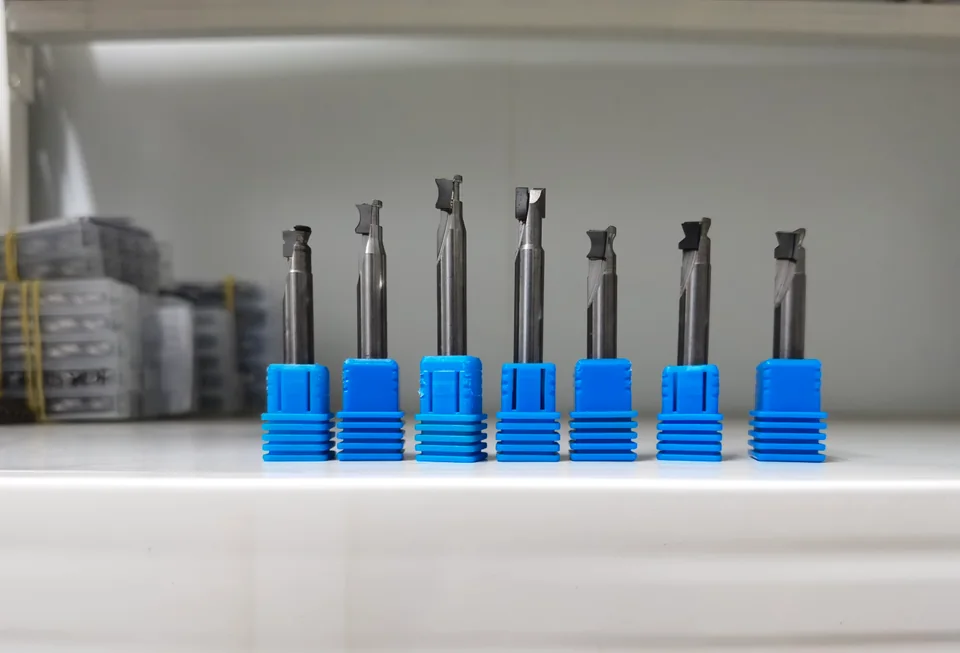 Seven DiamovaLab diamond cutting tools with different cutting profiles, photographed in blue holders