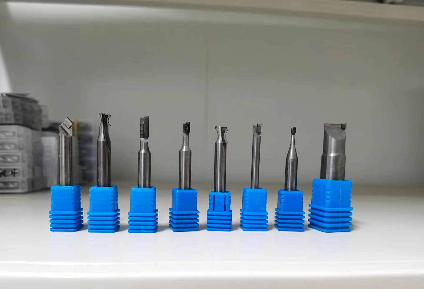 Client-supplied photograph of eight diamond cutting tools in blue holders