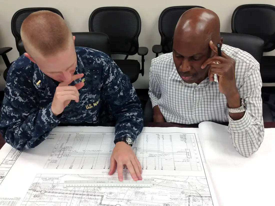 Engineering team reviewing technical project information at a workstation